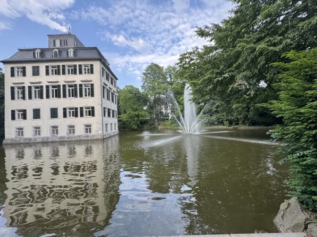 Holzhausenschlösschen im Frankfurter Holzhausenpark mit Weiher und Fontäne